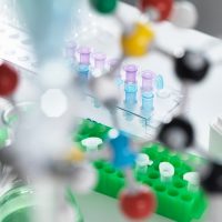 View through molecular model onto eppendorf tubes which are being used to test a sample in the laboratory